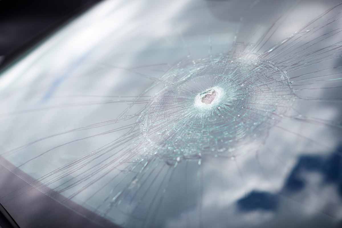 detail of damage to windscreen of car shattered