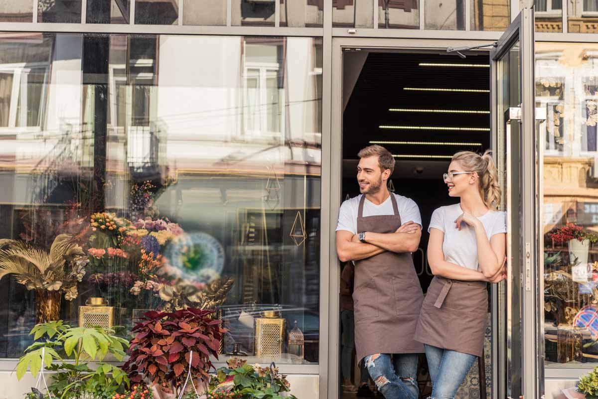 cheerful caucasian florists standing near flowers